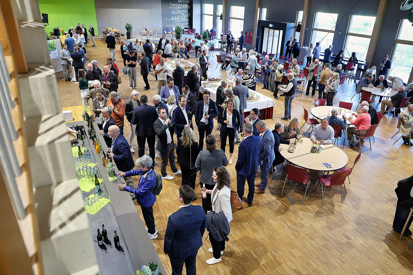 Bei einer Businessveranstaltung stehen Menschen zusammen und unterhalten sich.